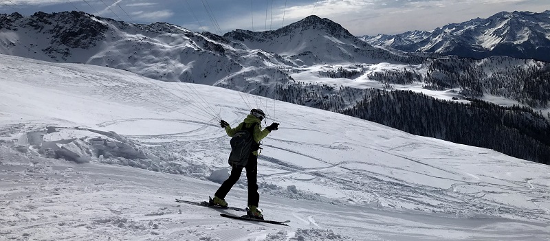 Une parapentiste qui effectue un décollage en ski
